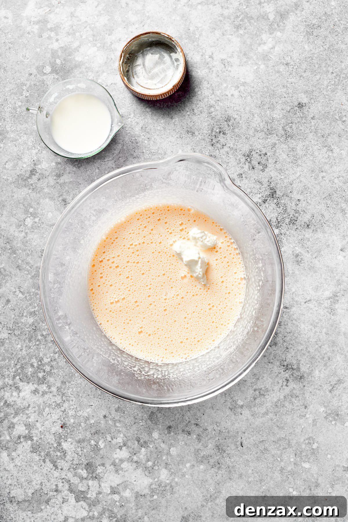 Add Sour Cream to Grinch Cake Batter for Enhanced Moisture Sour cream is added to the cake batter in a mixing bowl, ensuring a moist and rich texture.