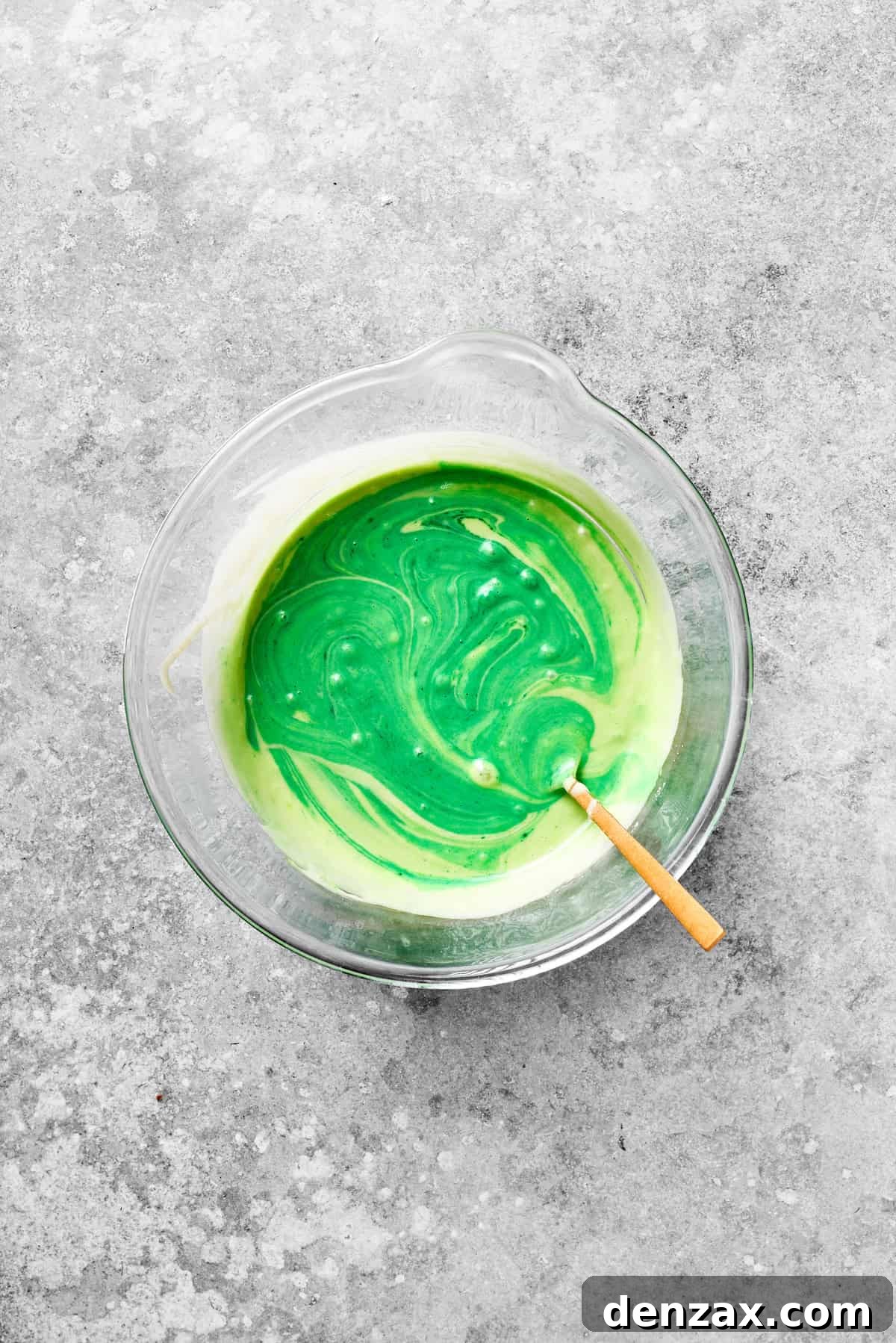 Stir Green Food Coloring into Grinch Cake Batter Green food coloring is stirred into the cake batter, transforming it into a vibrant Grinch-inspired hue.