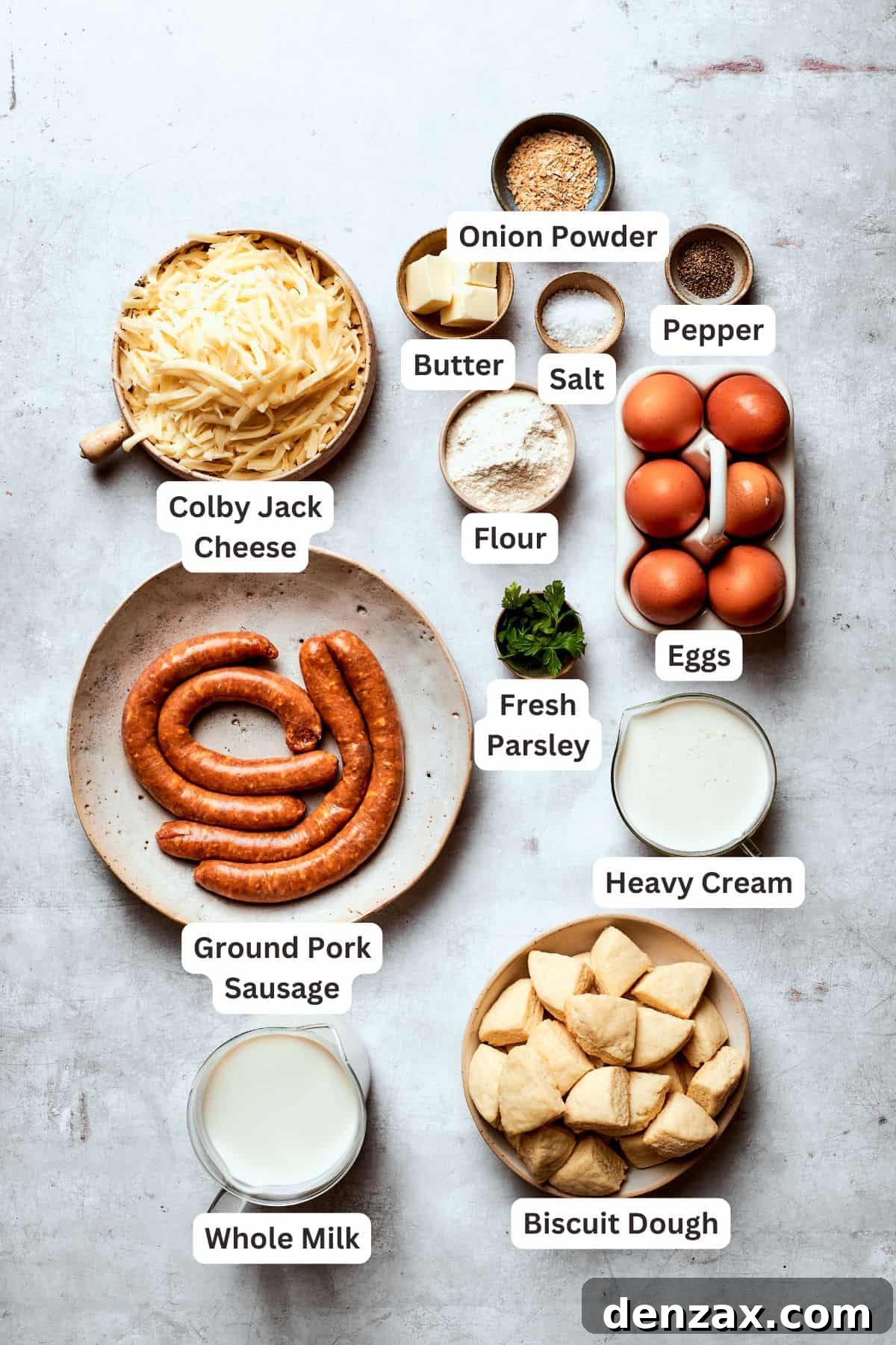 All the essential ingredients for making biscuits and gravy casserole are neatly arranged and text-labeled on a white surface.