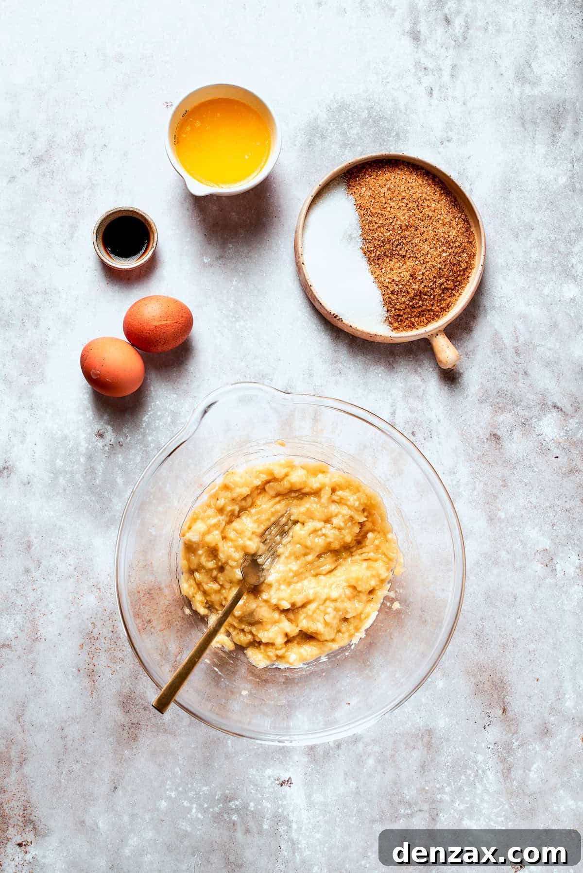 Mashing ripe bananas with a fork in a mixing bowl until smooth and creamy.