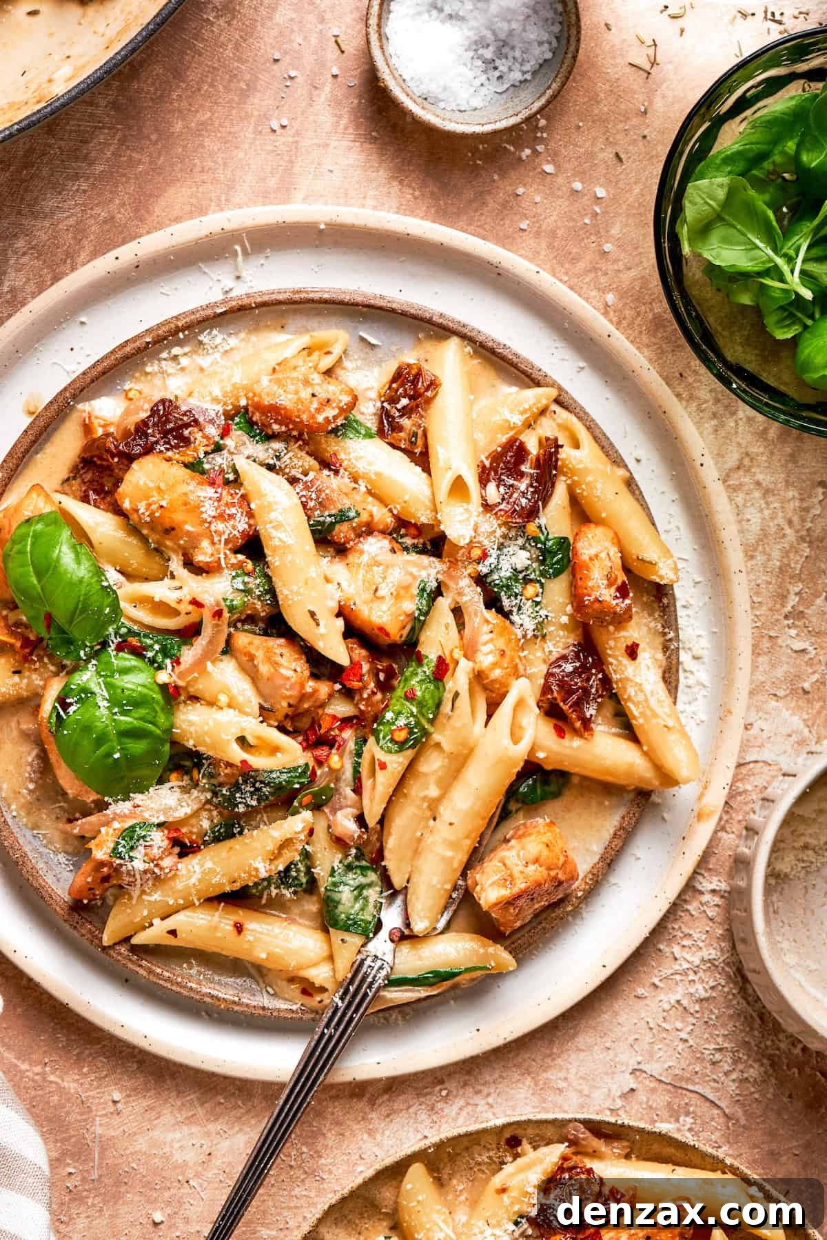 Basil leaves garnish a big plate of marry me chicken pasta.