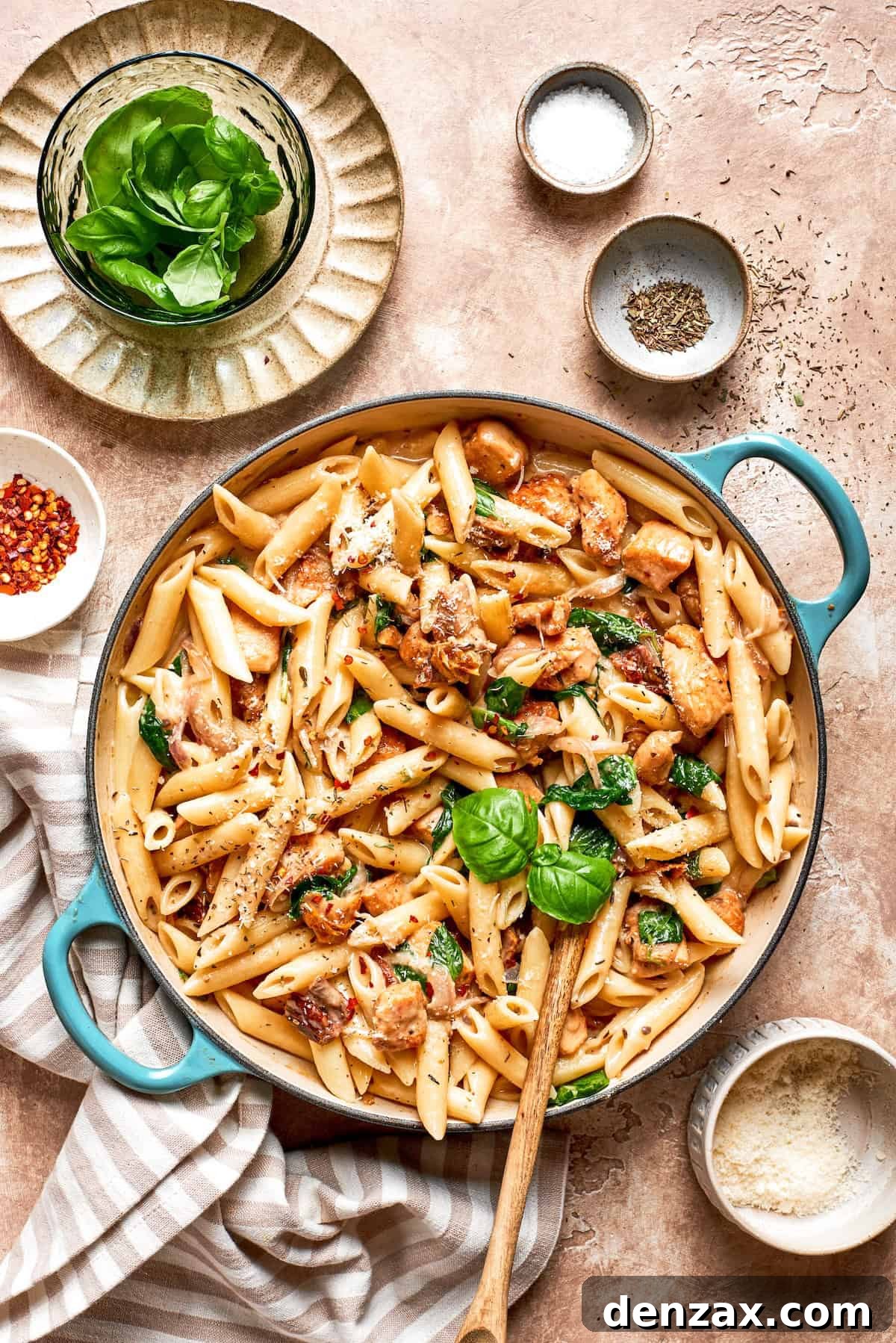 A skillet of marry me chicken pasta on a table.