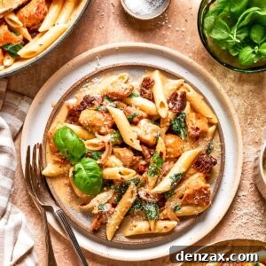 A plate of marry me chicken pasta garnished with fresh basil.