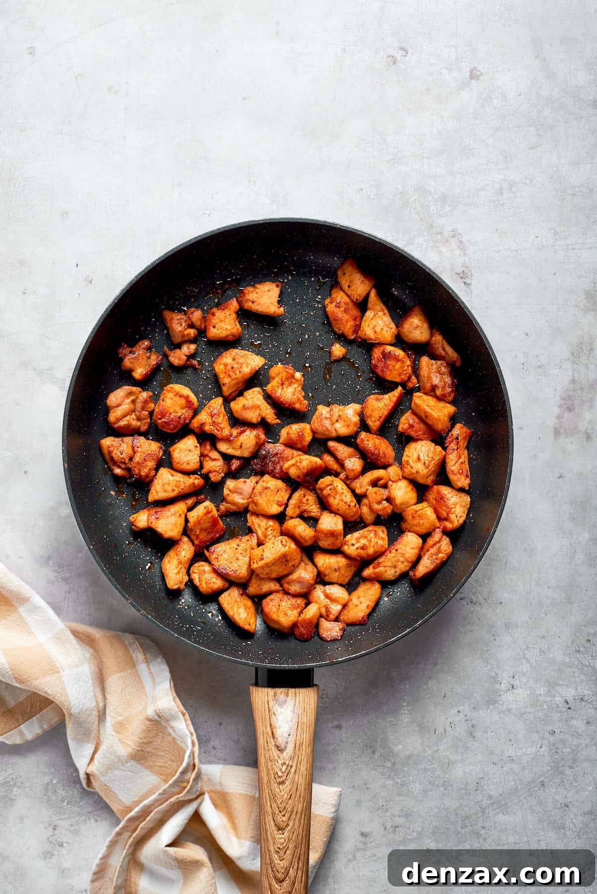Chicken pieces cooked until brown in a skillet.