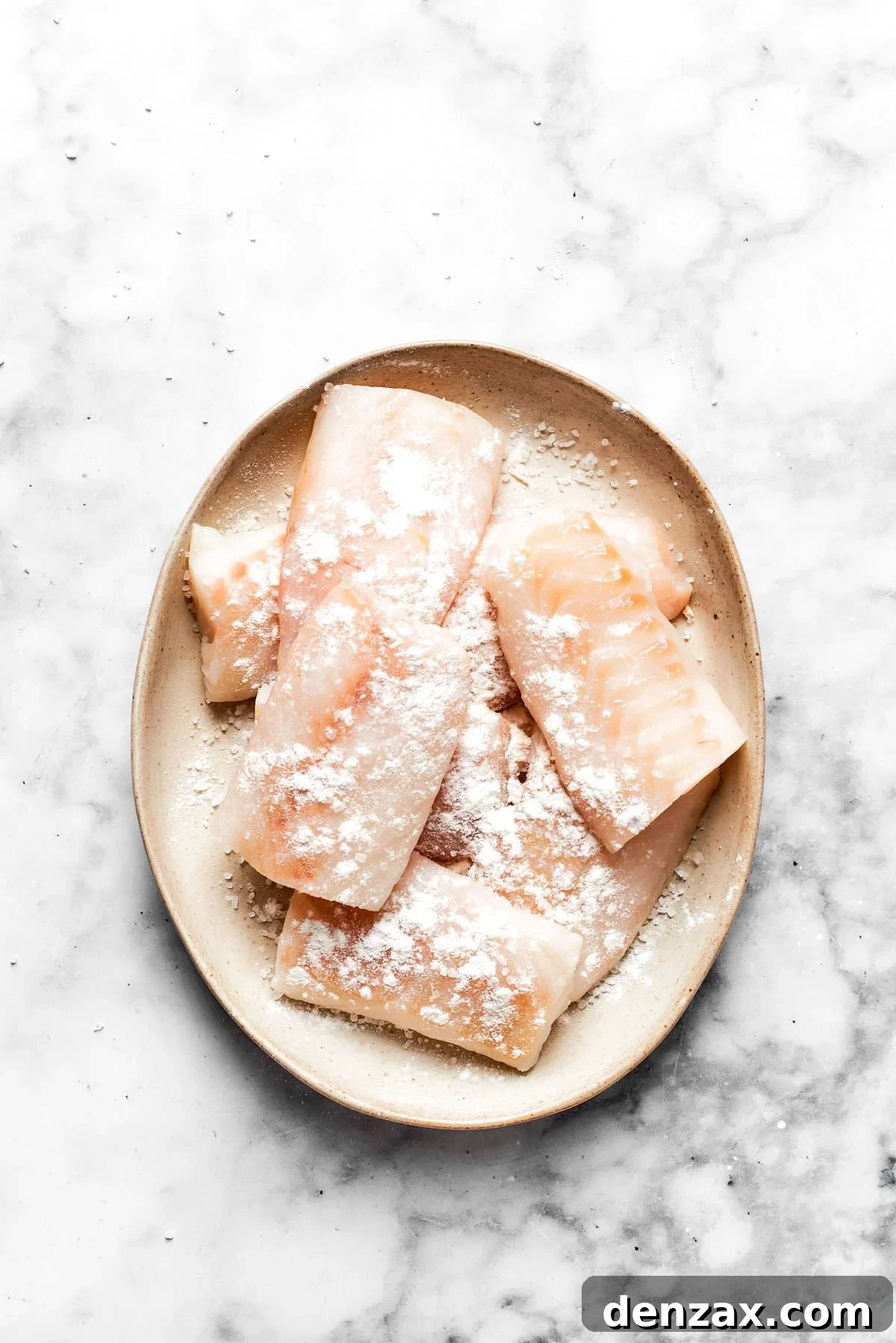 Pieces of fish fillets lightly dredged in flour, ready for the beer batter coating.