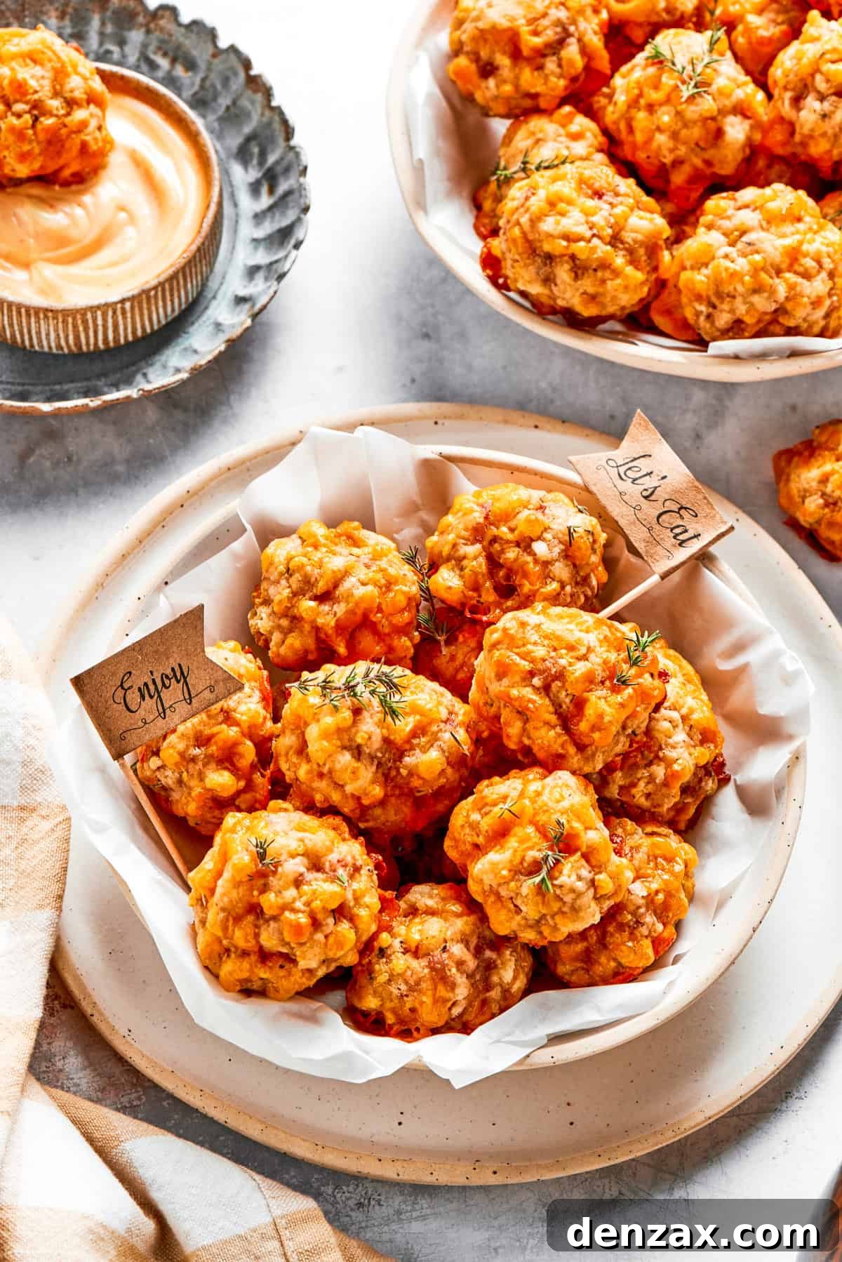 Two serving bowls overflowing with freshly baked, golden-brown sausage balls, ready for guests.
