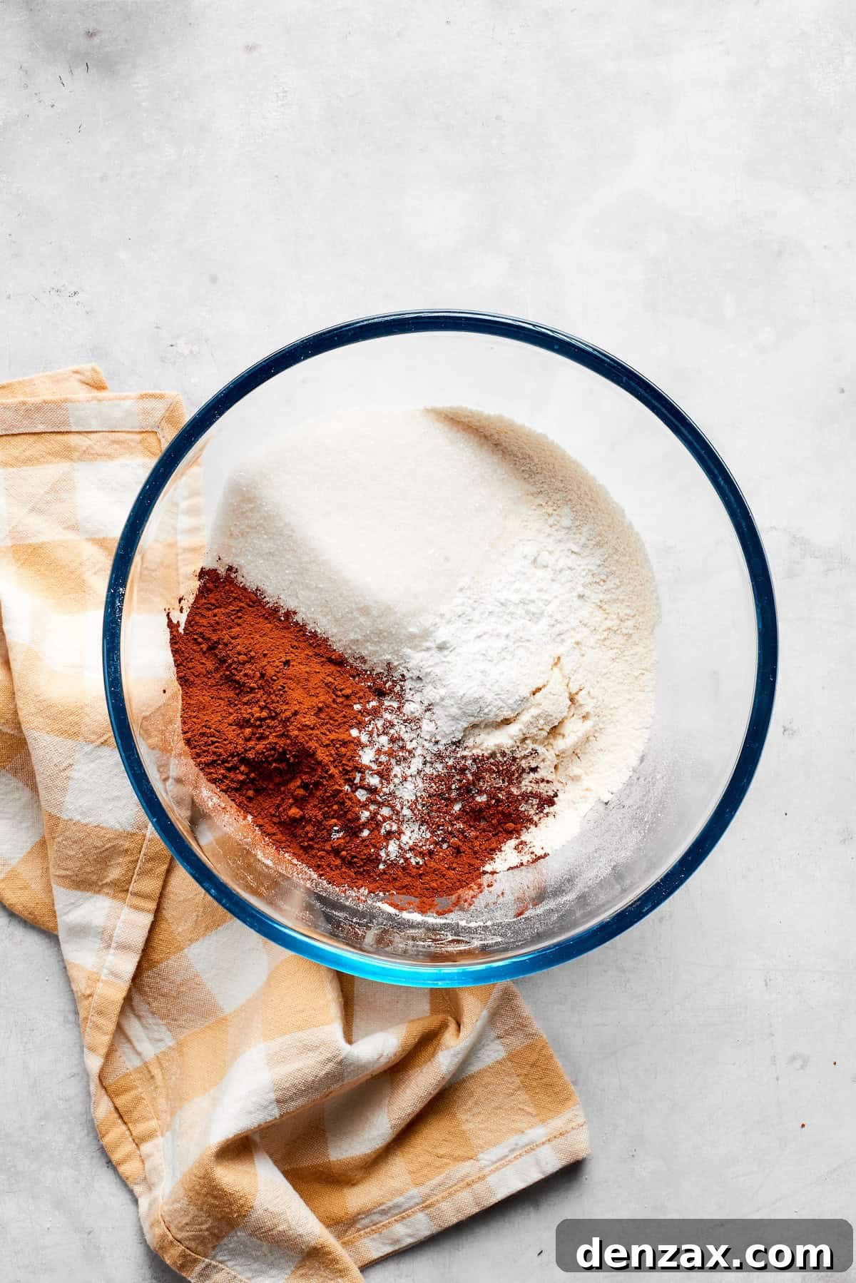 Dry ingredients for chocolate muffins are mixed in a bowl.
