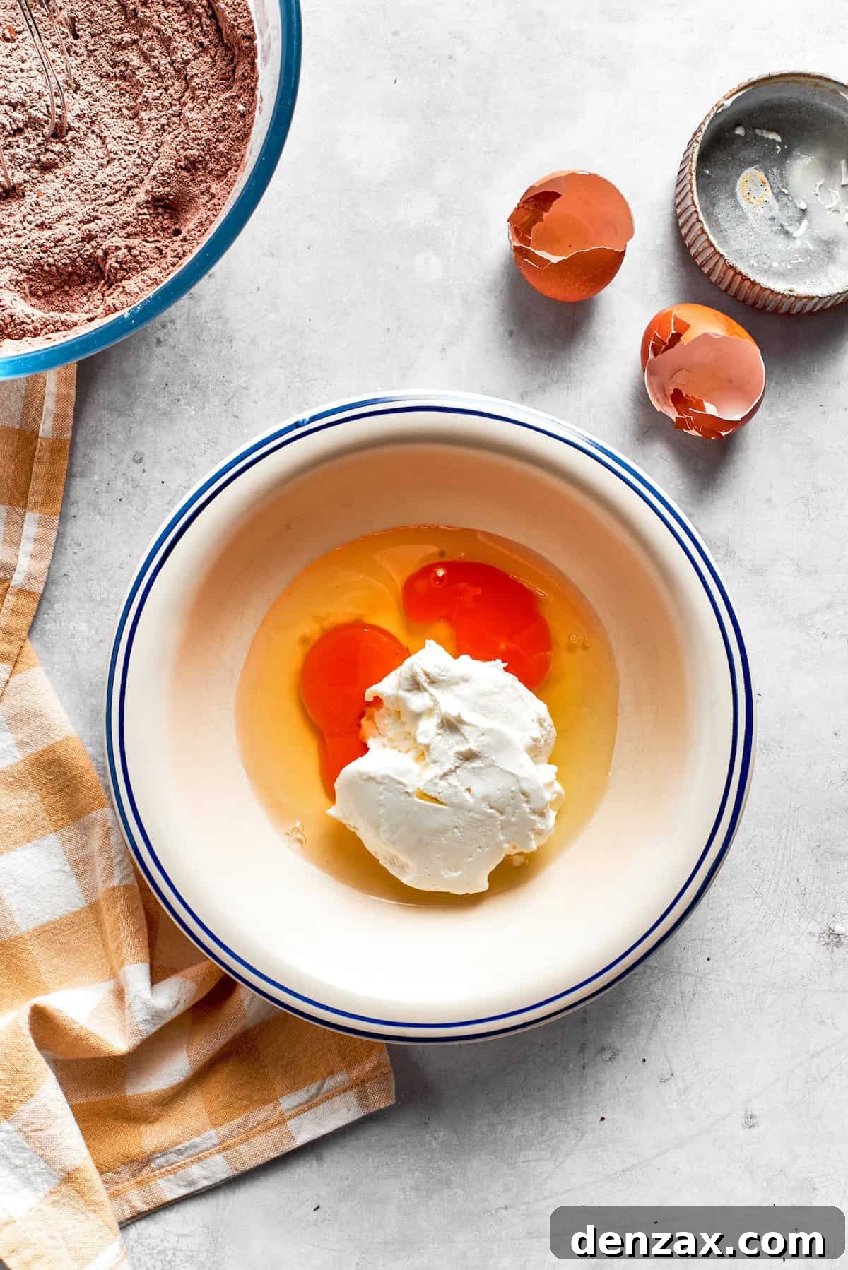 Eggs are mixed with sour cream in a bowl.