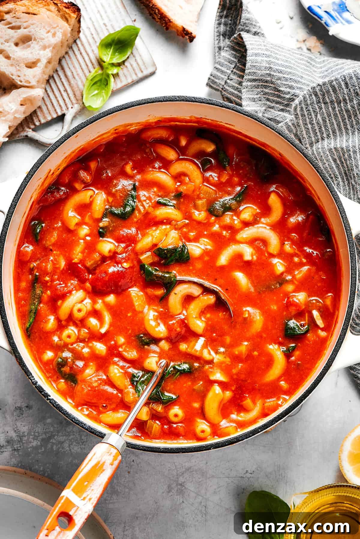 A steaming pot of vibrant Tomato Florentine Soup, garnished with fresh basil leaves and a sprinkle of Parmesan cheese.