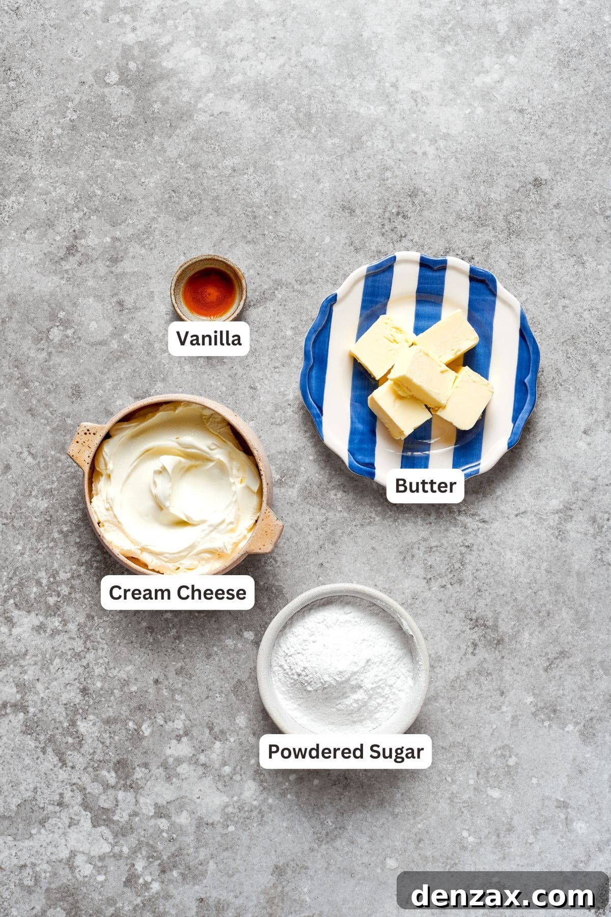 Various ingredients for cream cheese frosting, including cream cheese, butter, powdered sugar, and vanilla extract, are neatly arranged and labeled.
