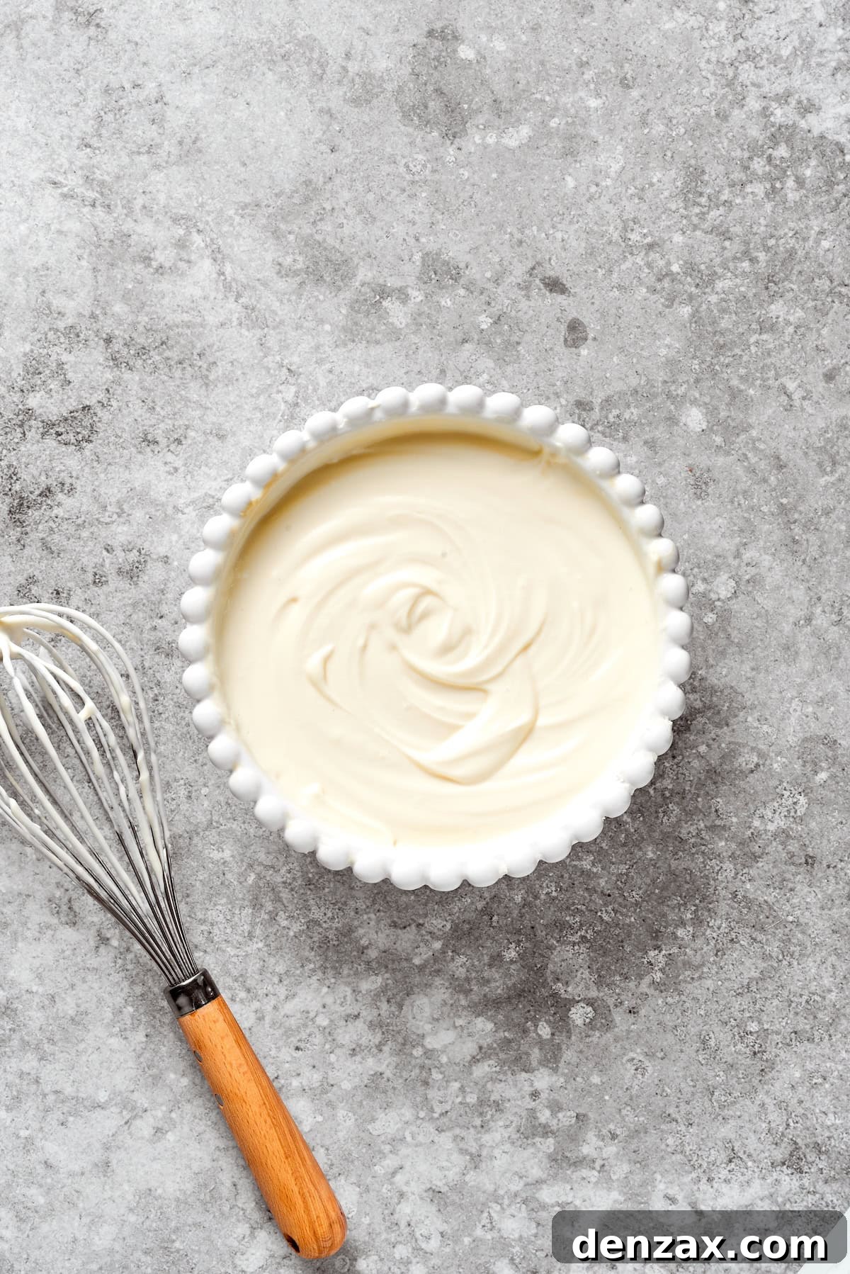 A bowl of perfectly smooth and creamy cheesecake batter, ready for layering.