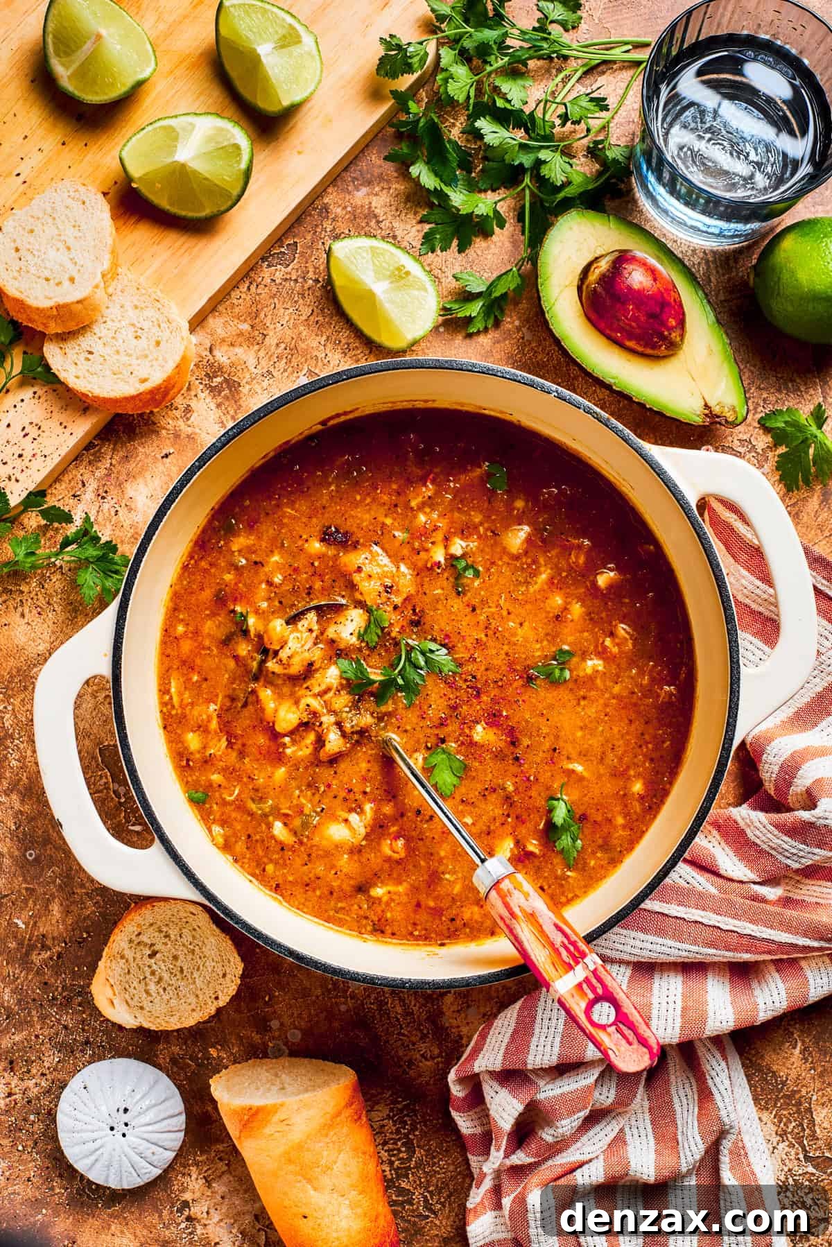 A close-up view of spicy chicken and pinto bean soup simmering gently in a large pot, showcasing the rich texture and vibrant colors of the broth, beans, and shredded chicken. Steam rises, hinting at its warmth and inviting aroma.