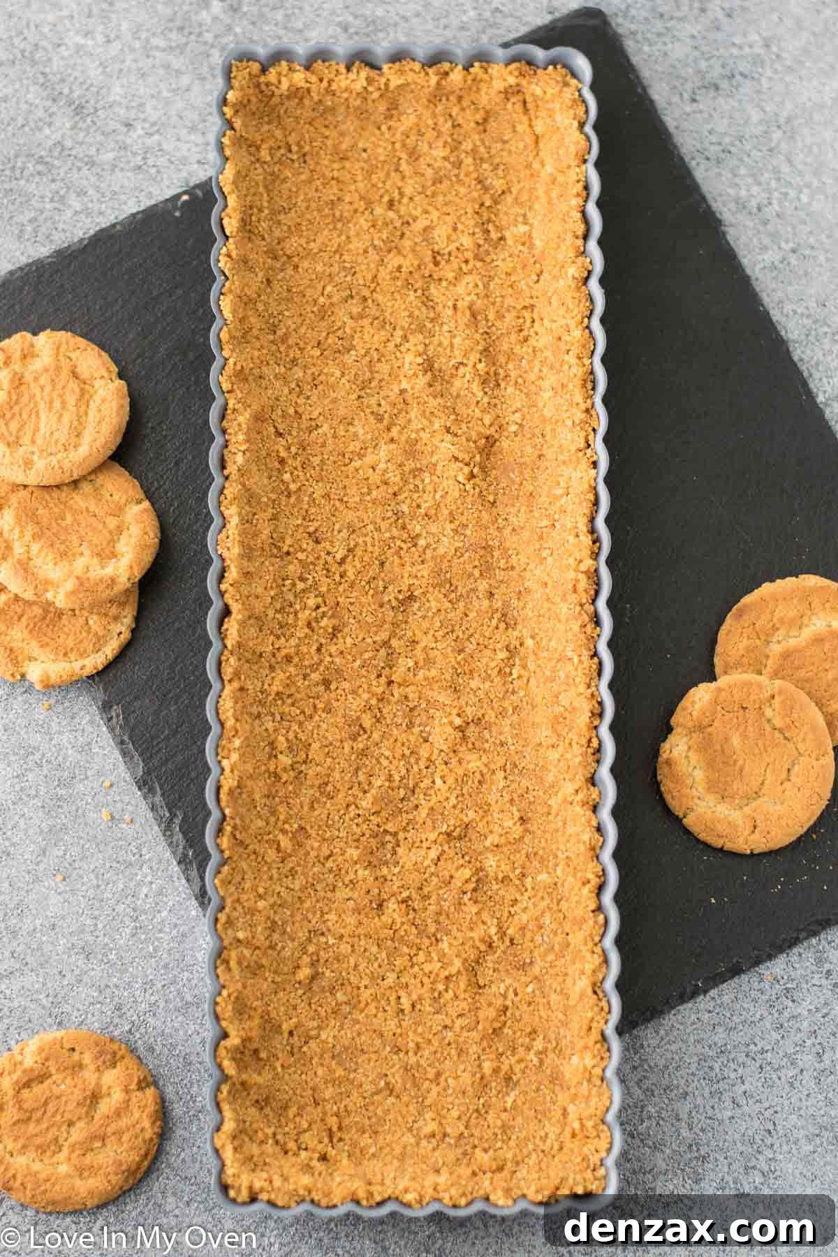 Gingersnap cookie crumbs mixed with butter, cinnamon, and salt, ready for forming into a tart crust.