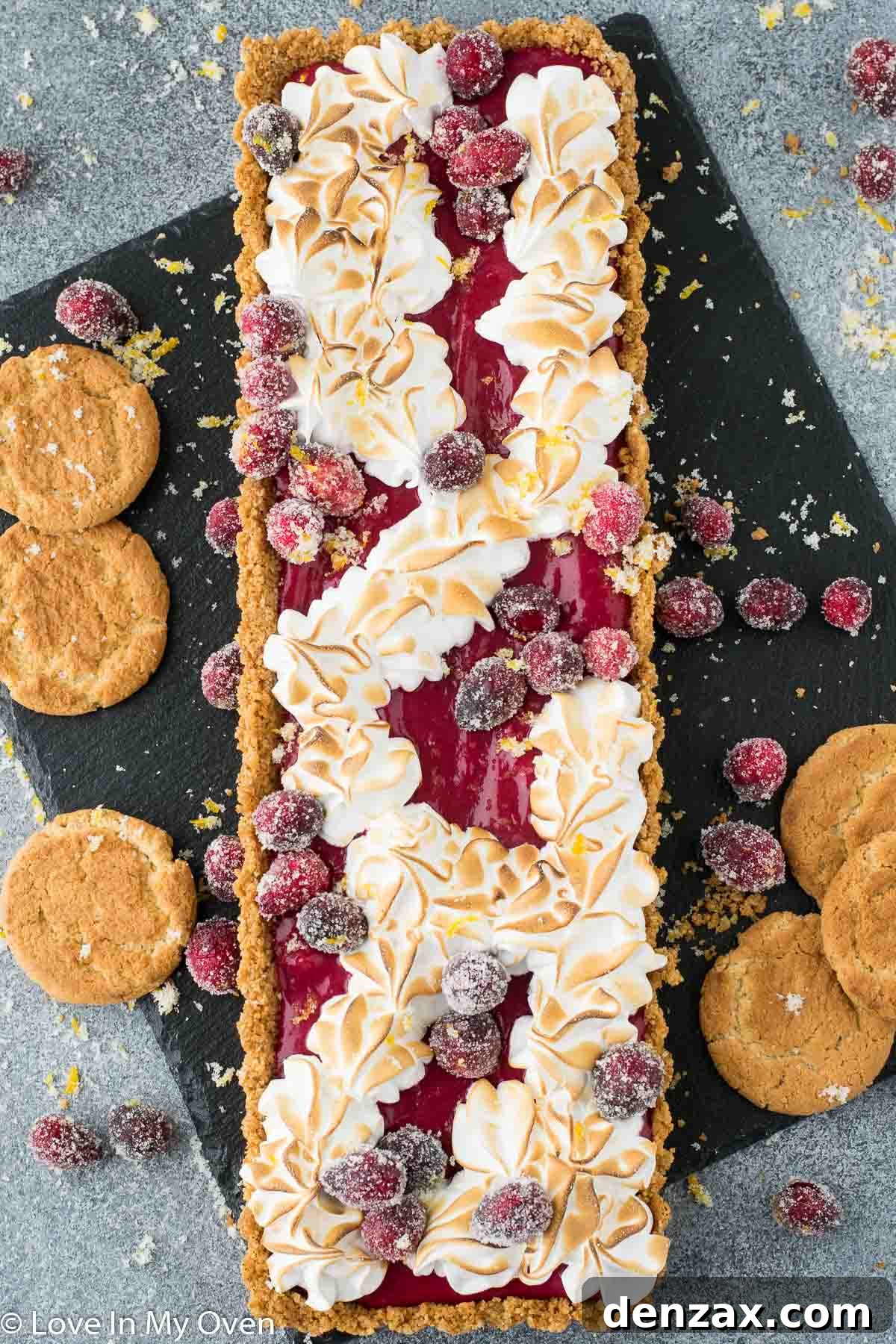 Torched Swiss meringue topping on a cranberry curd tart, showcasing beautiful golden peaks.