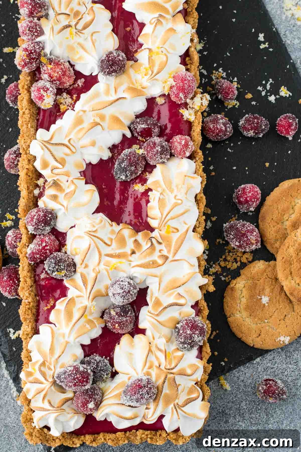 Slice of Cranberry Curd Tart with meringue, showcasing layers of crisp crust, smooth curd, and fluffy topping.