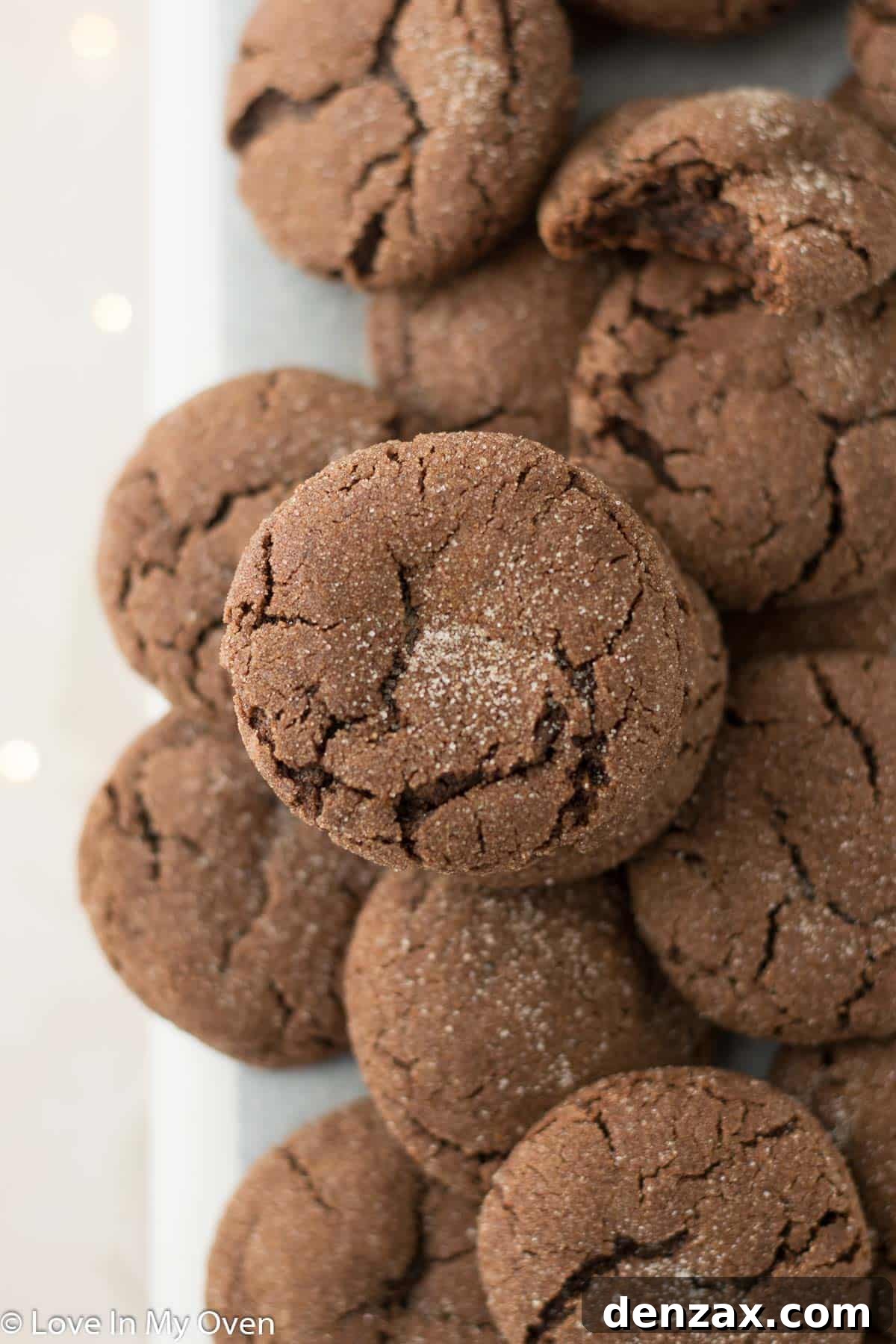 A hand reaching for a chocolate snickerdoodle on a plate
