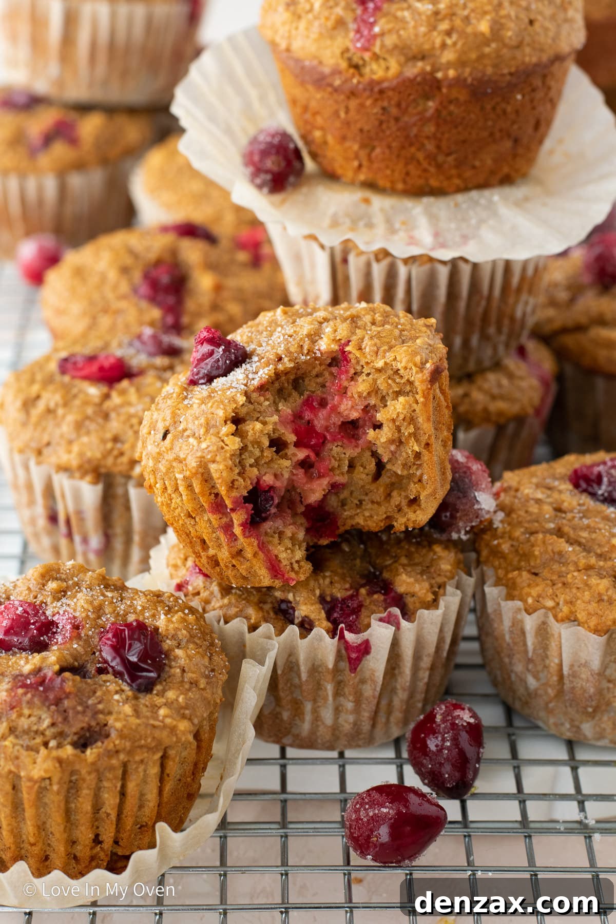 Two cranberry bran muffins stacked, showing their fluffy interior and juicy cranberries.