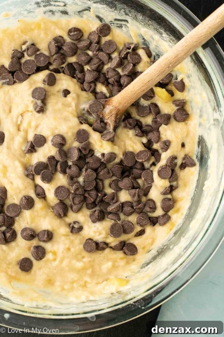 Muffin batter being scooped into a jumbo muffin tin, ready for baking.