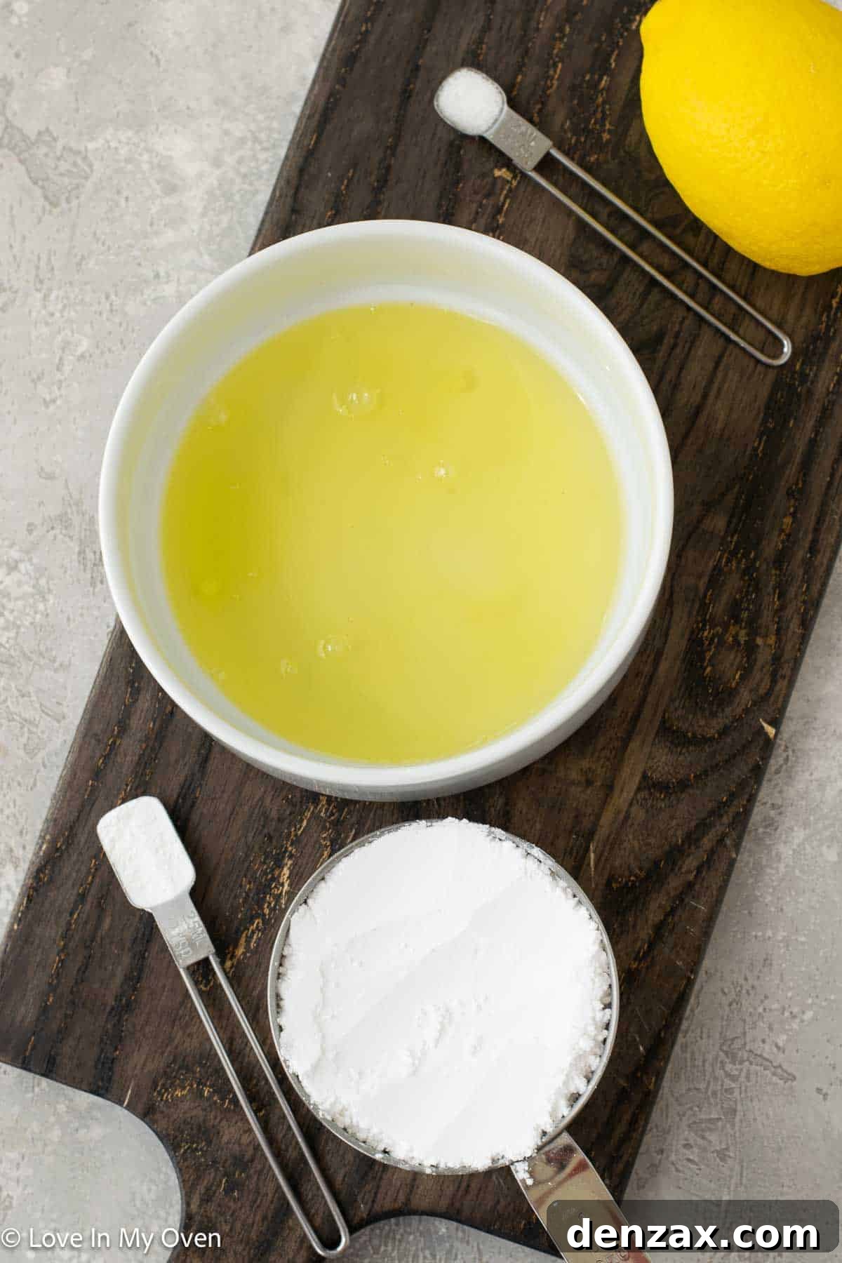 A bowl of fresh ingredients including egg whites, powdered sugar, and lemons, ready to be transformed into lemon meringue cookies.
