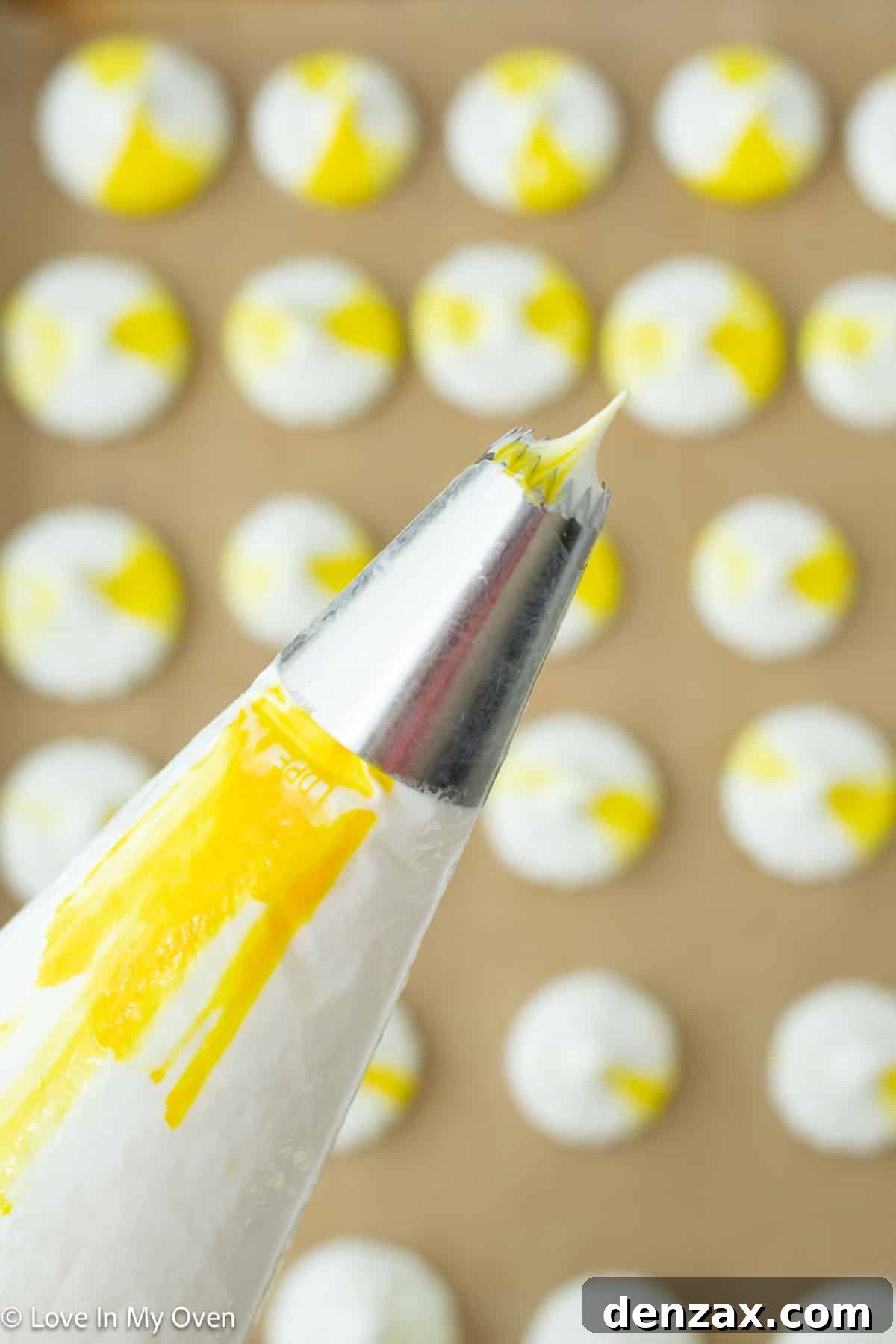 Close-up of lemon meringue cookies being piped, showcasing uniform shapes and the vibrant yellow streaks.