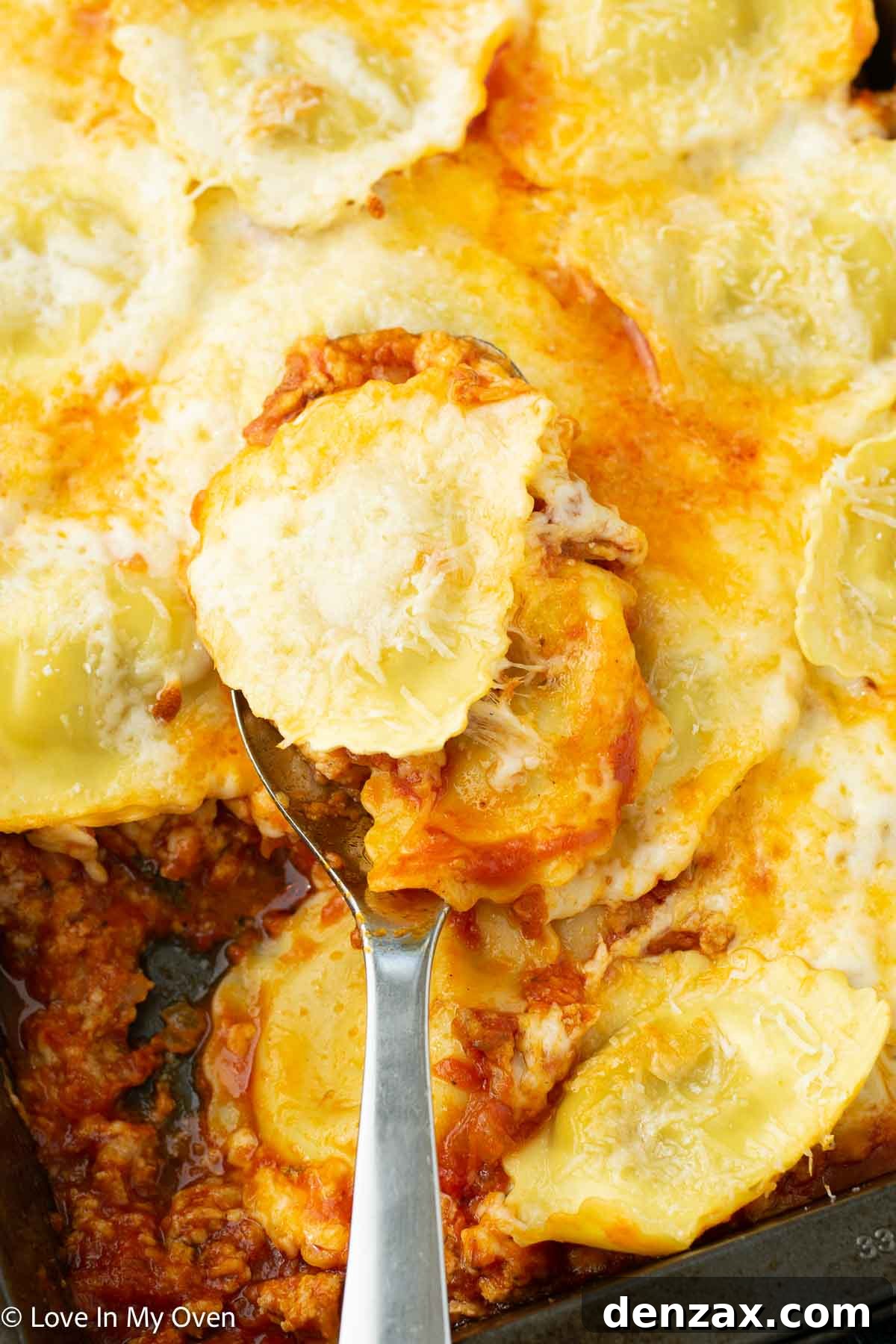 Serving spoonful of cheesy sausage ravioli bake