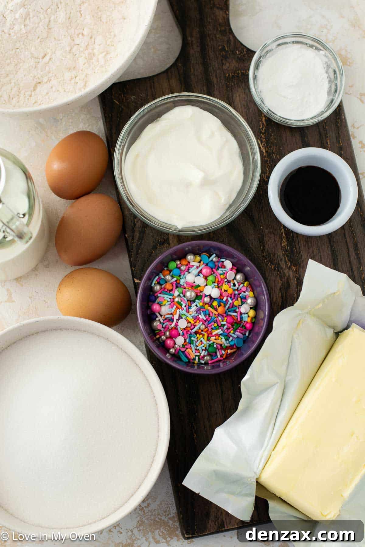 Close-up of baking ingredients for sprinkle cake, including butter, eggs, flour, and sprinkles