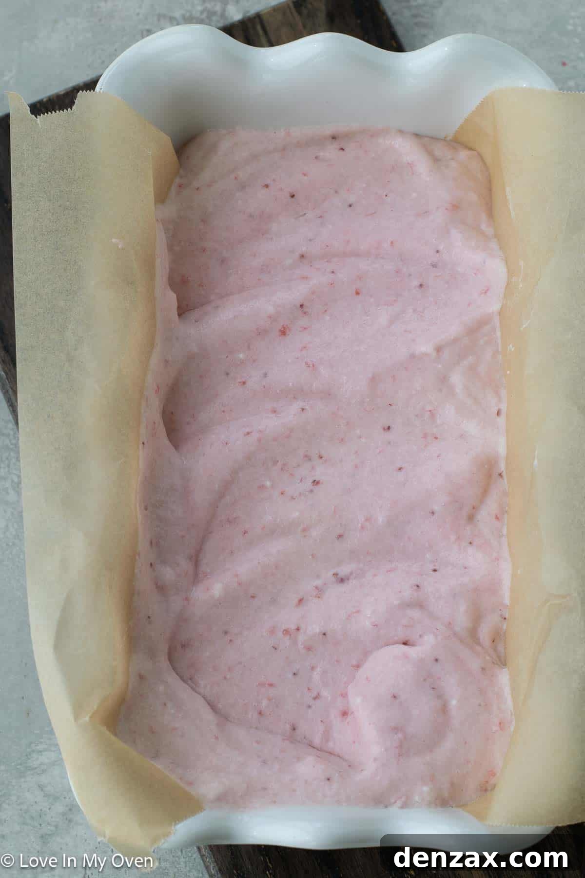 Strawberry semifreddo mixture poured into a parchment-lined loaf pan
