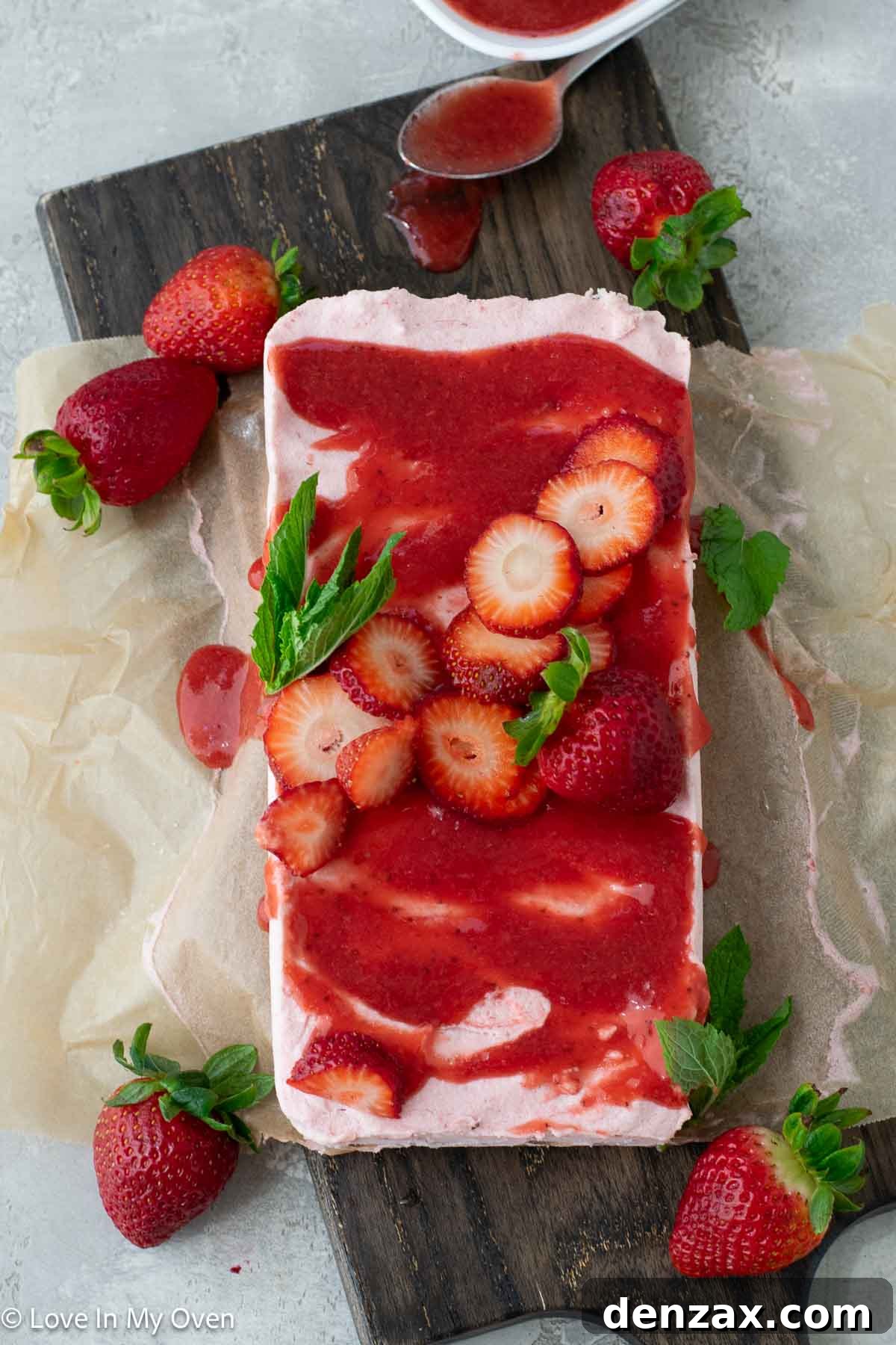 A perfectly sliced piece of Strawberry Semifreddo topped with extra strawberry sauce