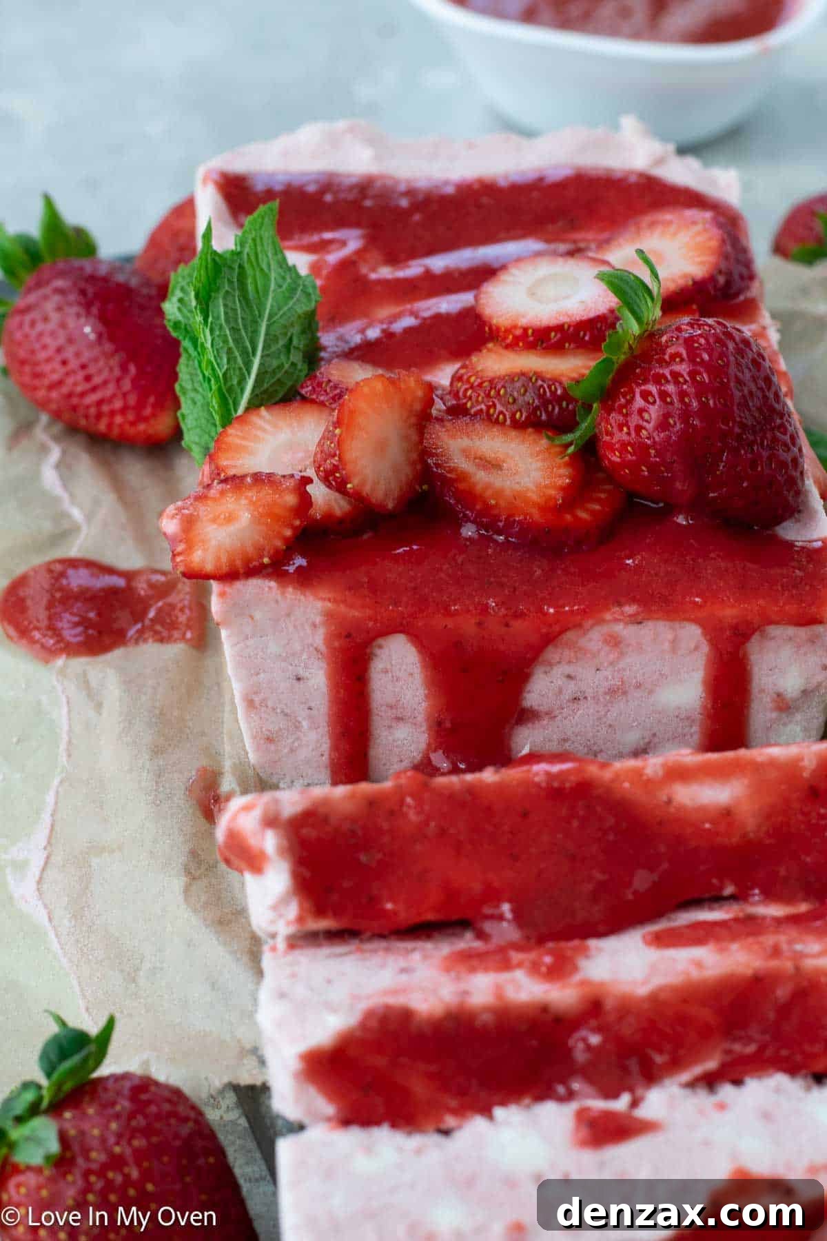 Two elegant slices of Strawberry Semifreddo on a white plate, garnished with fresh strawberries
