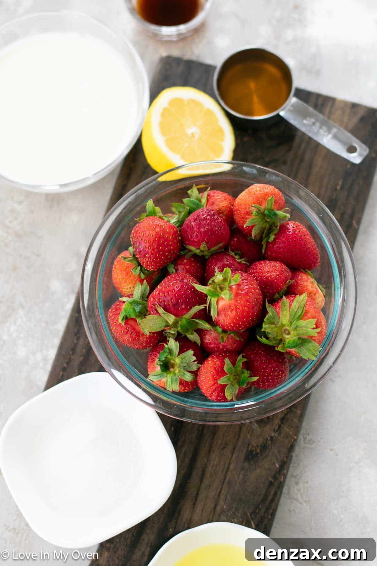 Fresh ingredients laid out for making Strawberry Semifreddo, including ripe strawberries, honey, and cream