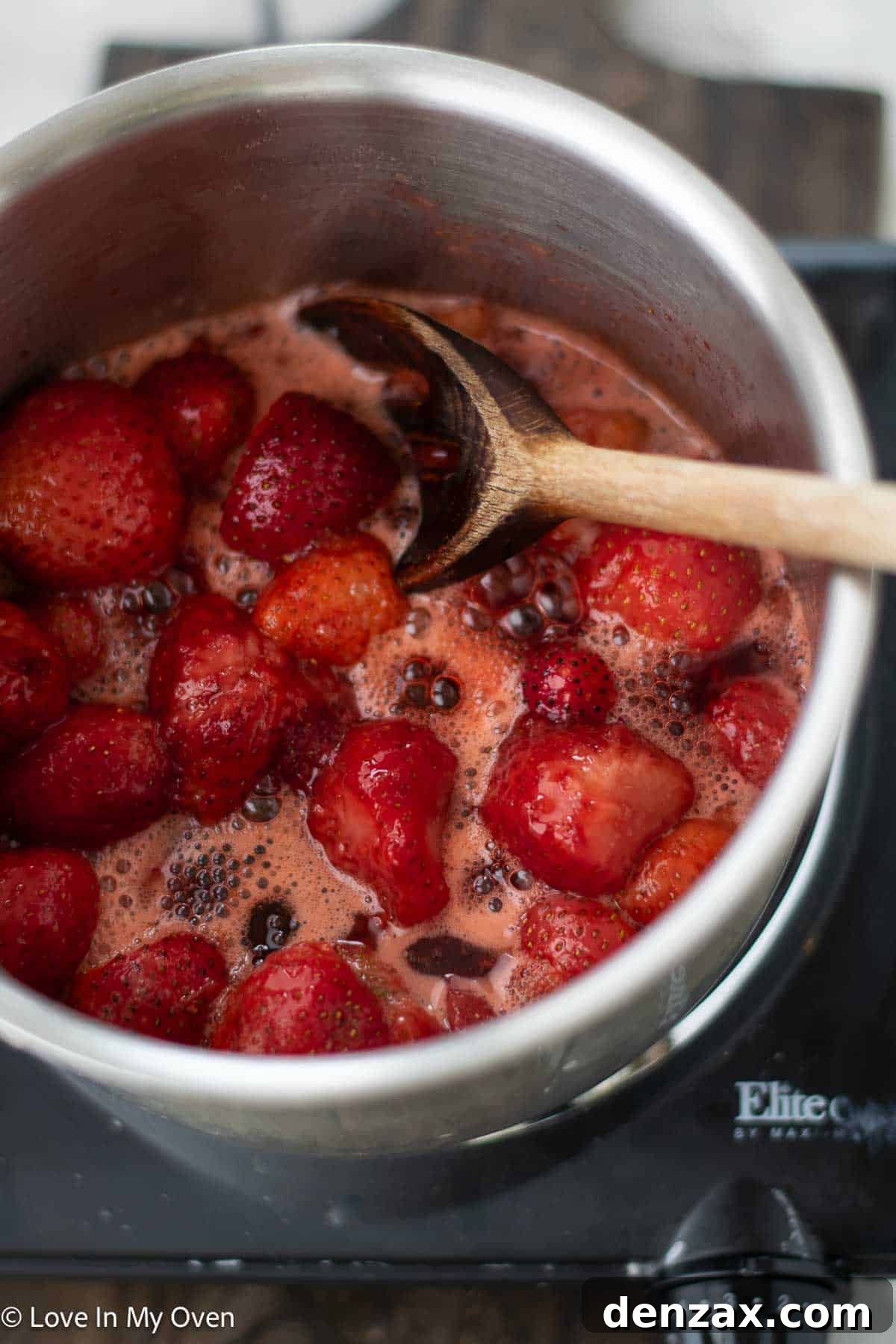 Strawberry sauce being pureed with an immersion blender