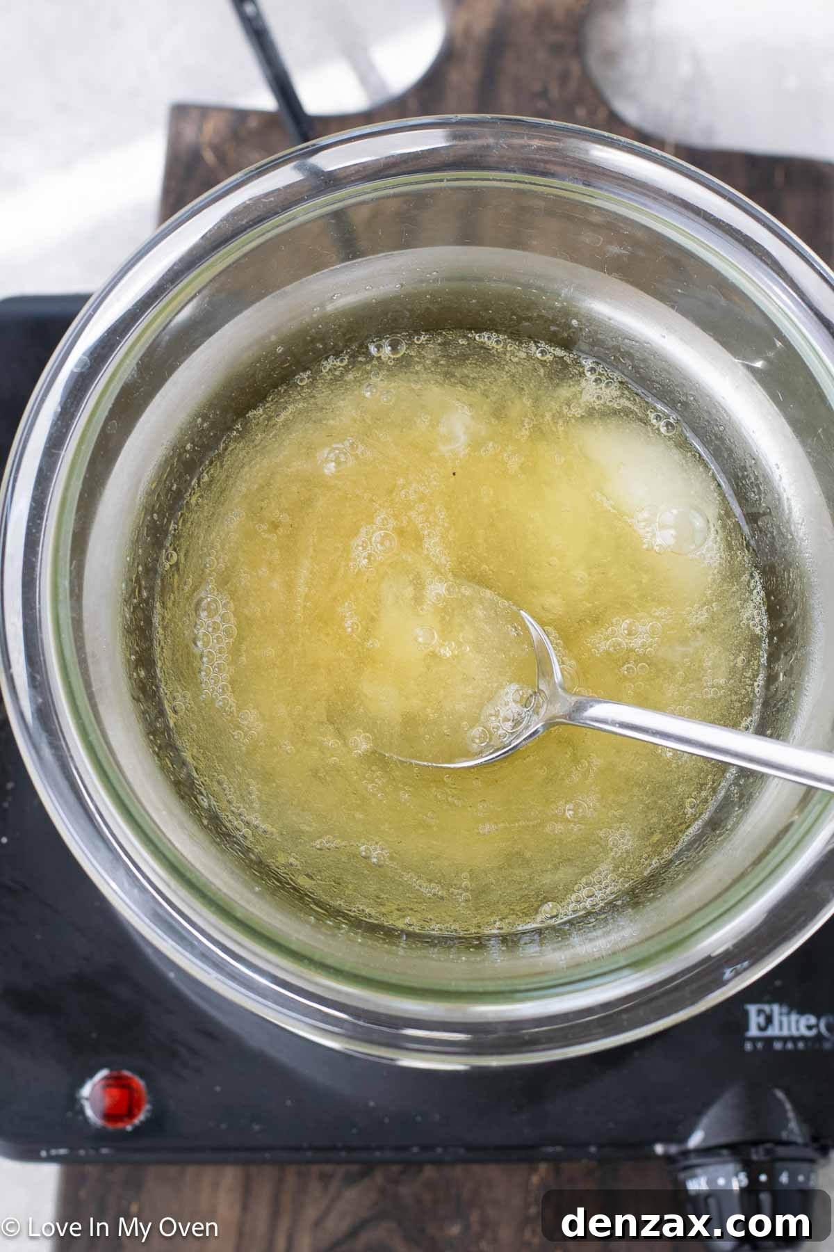 Egg whites, sugar, and honey being whisked over simmering water for the meringue base