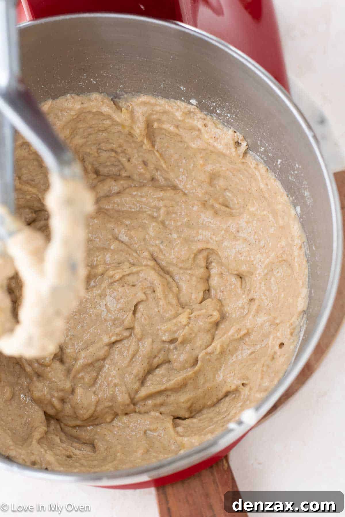 Nutella being gently swirled into banana bread batter with a knife