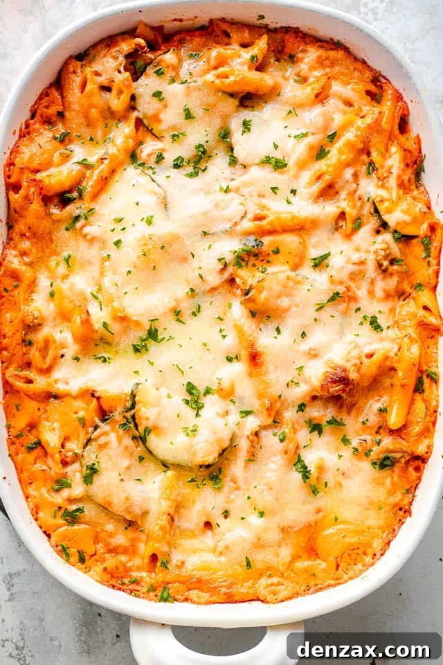 Overhead shot of a cheesy baked pasta and zucchini casserole, golden brown and bubbly from the oven.