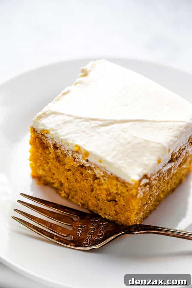 side shot of frosted pumpkin bar on a plate with a fork next to it
