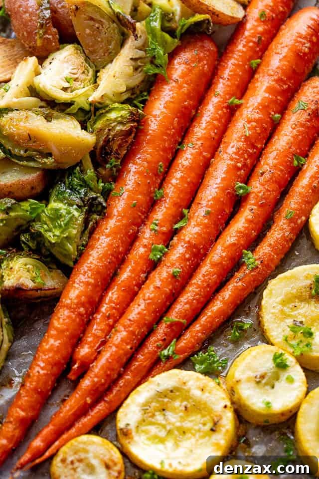 Overhead shot of roasted whole carrots, glistening with herbs and glaze