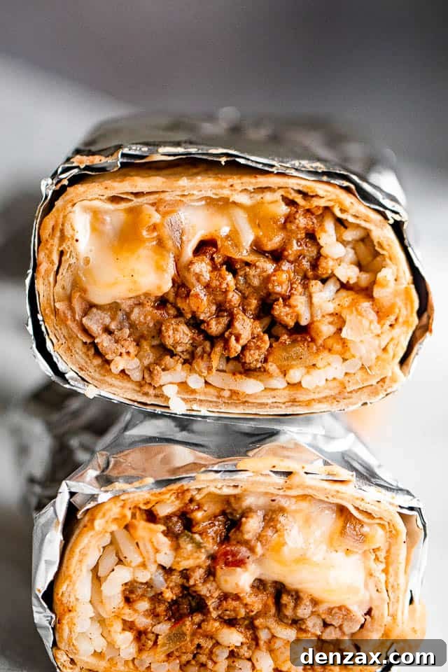 Close up of two halved beef and bean freezer burritos stacked, showing the rich filling of meat, beans, and cheese.