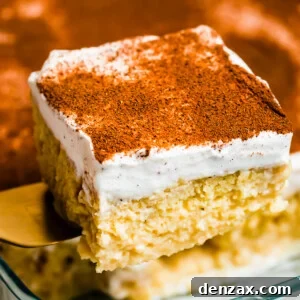 Lifting out a piece of tres leches cake from a glass baking dish.