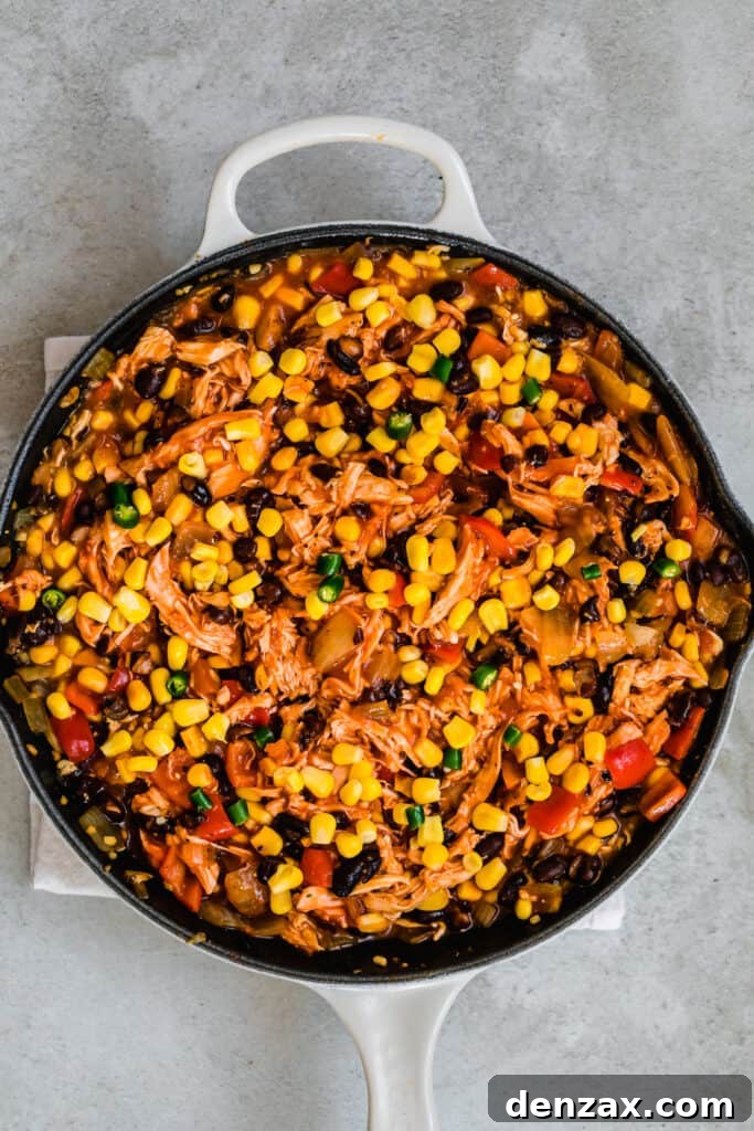 A Large Skillet Filled With A Hearty Chicken Enchilada Casserole