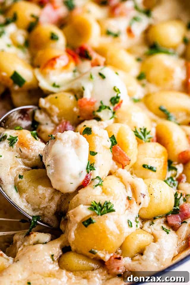 up close shot of a spoon in gnocchi casserole, showing its creamy texture
