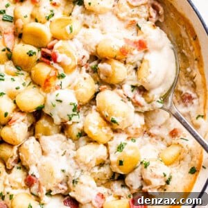 spooning out creamy gnocchi from a casserole dish