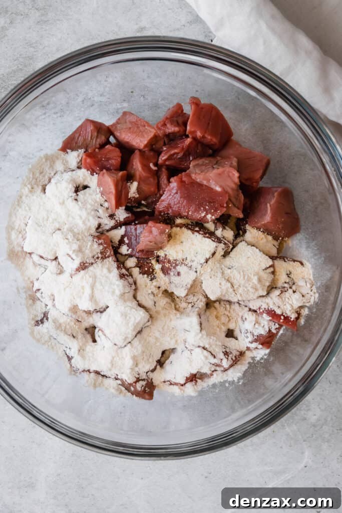 A Glass Bowl Holding the Beef and Flour Mixture