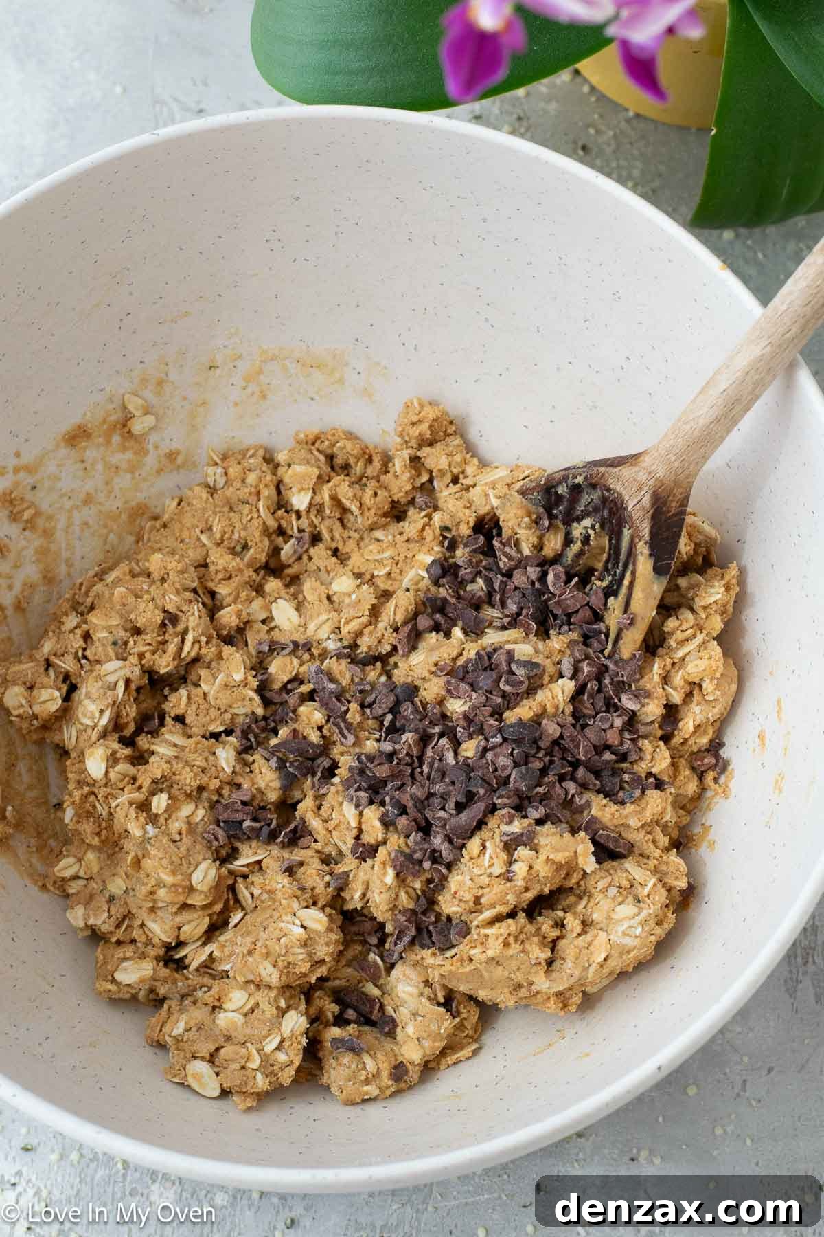 Adding cocoa nibs to the peanut butter protein ball mixture.