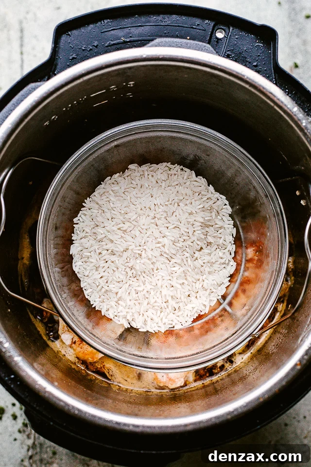 Placing a separate dish of rice into the Instant Pot, nestled above the chicken and sauce, for simultaneous cooking.