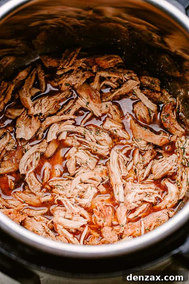 Shredded chicken returned to the thickened honey garlic sauce in the Instant Pot, ready to be served.