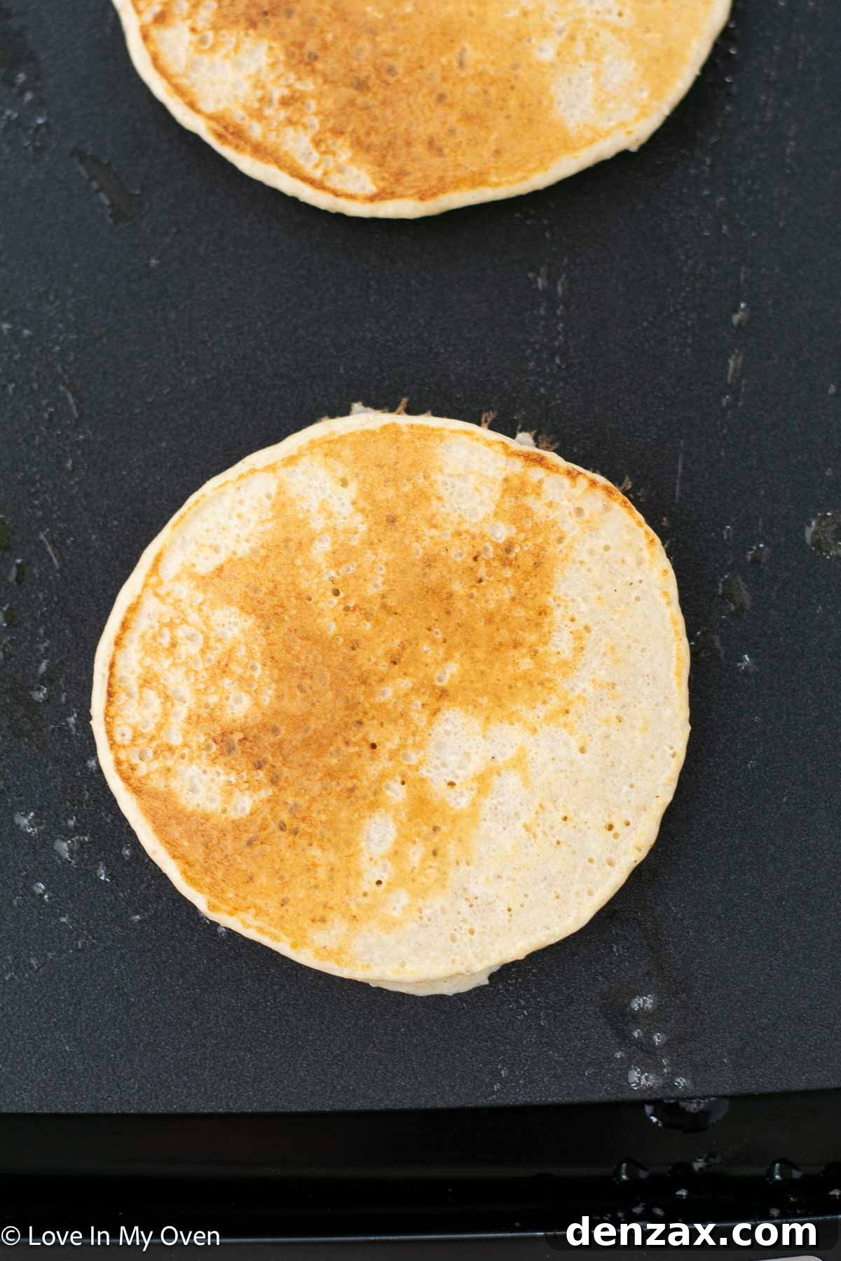 Pancakes on a griddle being cooked.
