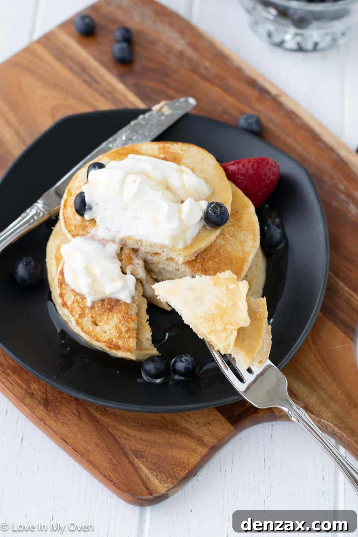 Close-up of a single high protein pancake with a bite taken out, showing its fluffy interior.