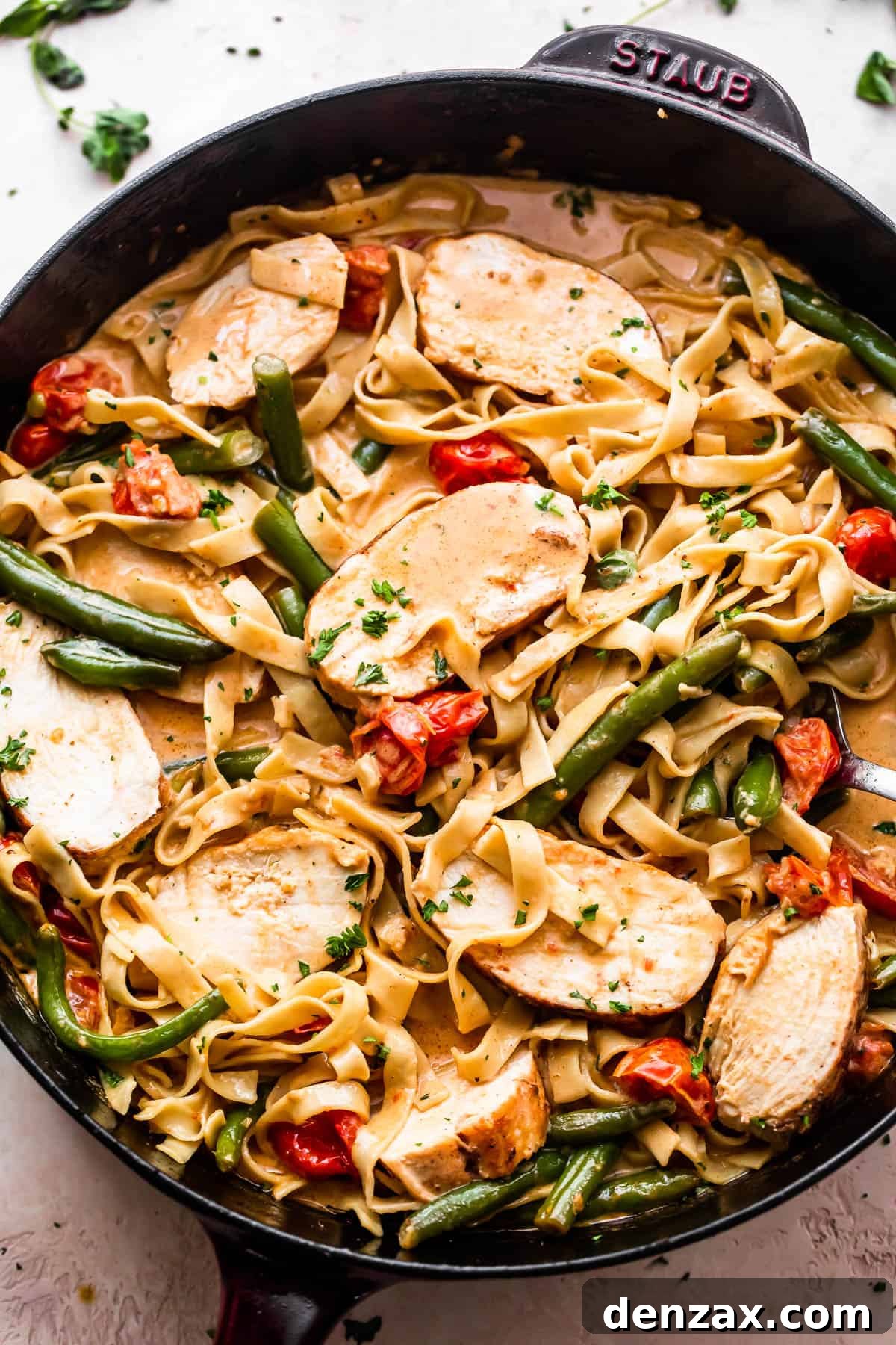 overhead shot of a skillet with Creole Blackened Chicken with Pasta, tomatoes, and green beans