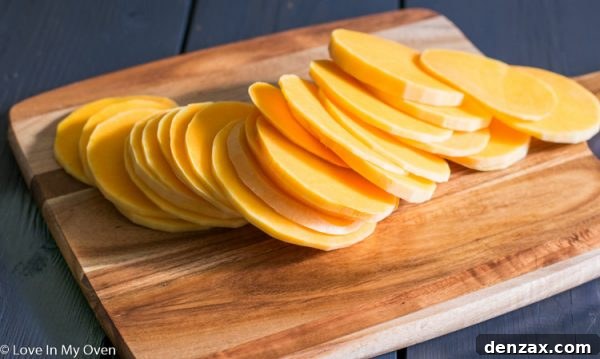 Butternut squash slices on a baking sheet, lightly drizzled with olive oil