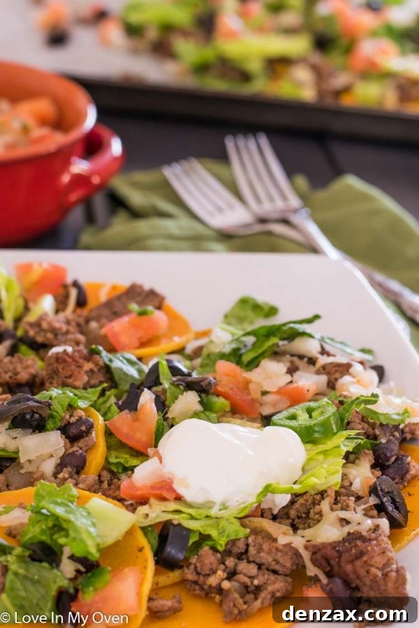Butternut squash nachos with various toppings, presented on a wooden board